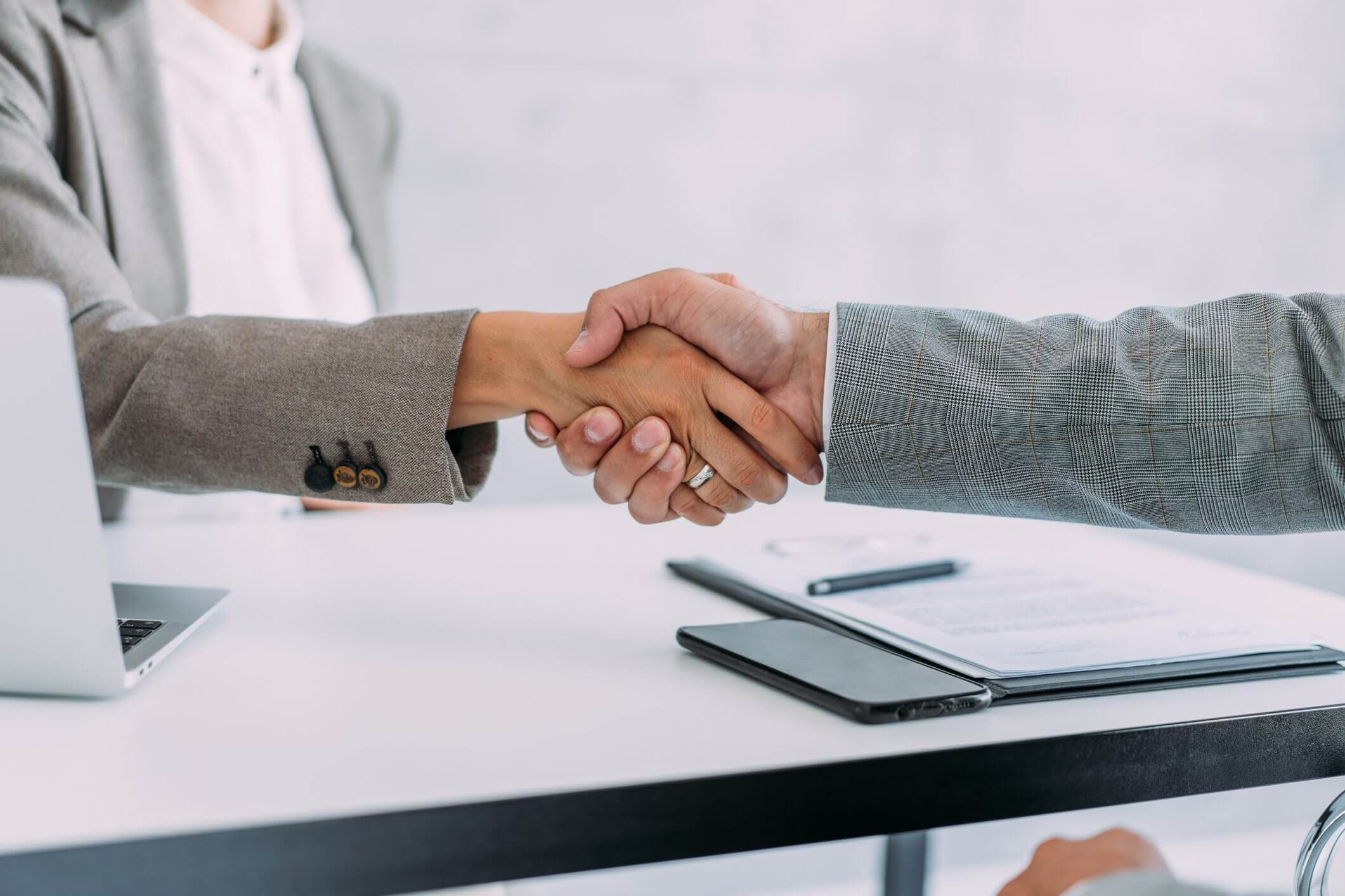 Handshake over a desk in an office.