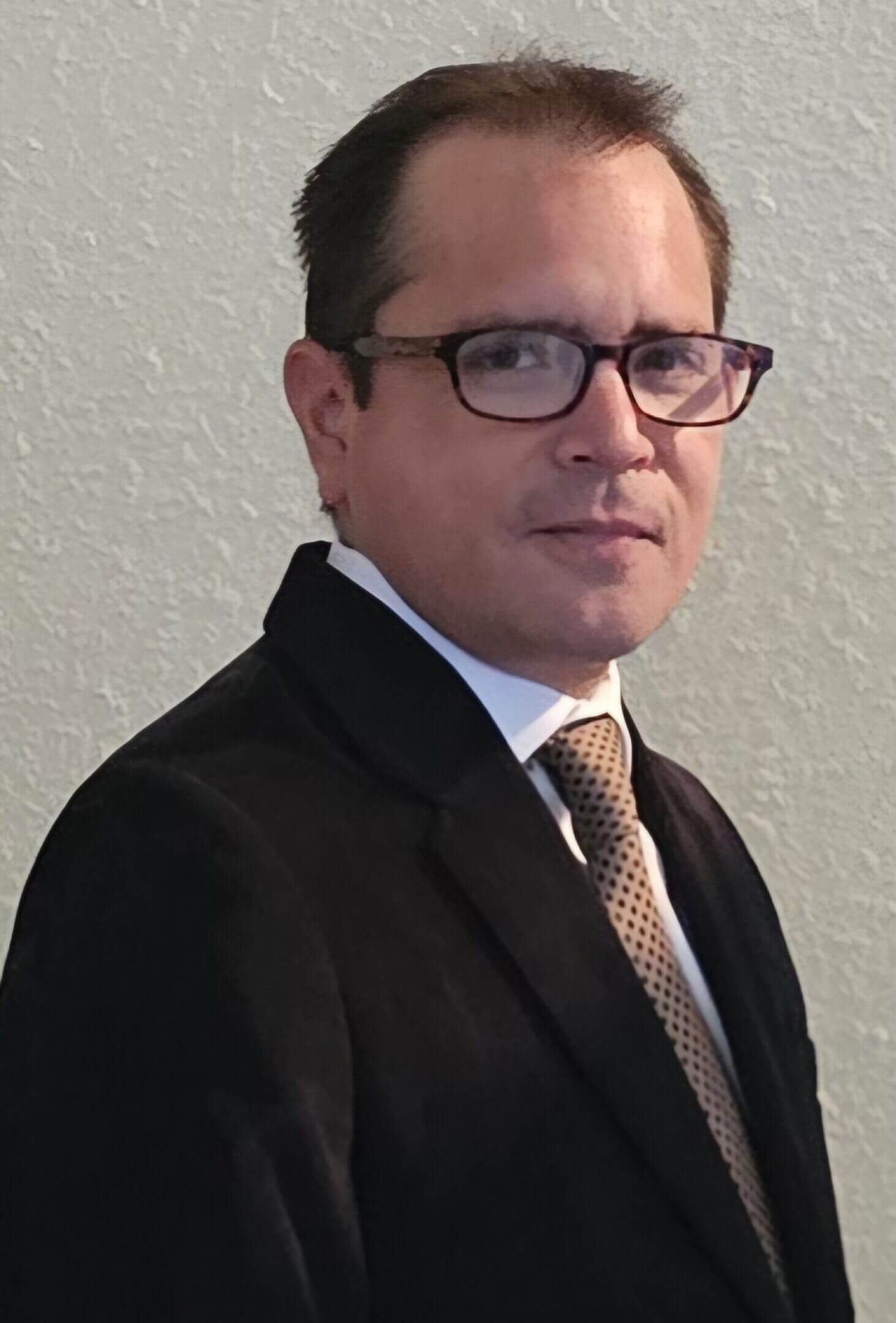 Man wearing glasses and a suit.